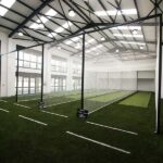 Synthetic Cricket Facilities Rondebosch-Boys-Indoor-Image1 | Synsport Indoor sports facility with a large netted batting cage over artificial turf and white lines on the field