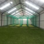 Synthetic Cricket Facilities Somerset College | Synsport Indoor sports facility with green turf and batting nets forming three lanes down the center