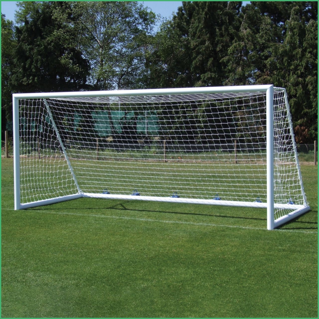 Synsport sports equipment - 9v9 soccer goals free standing units | Synsport Soccer goal with white frame and net on a grassy field, with trees in the background.